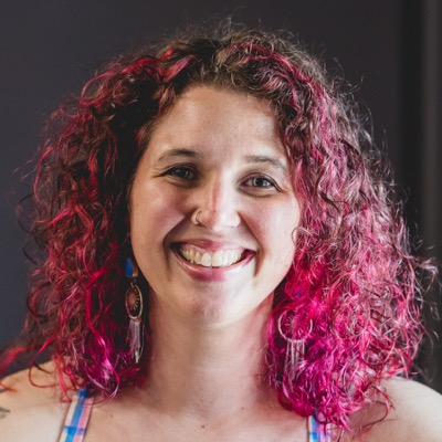 Kayla, smiling, with bright pink curly hair